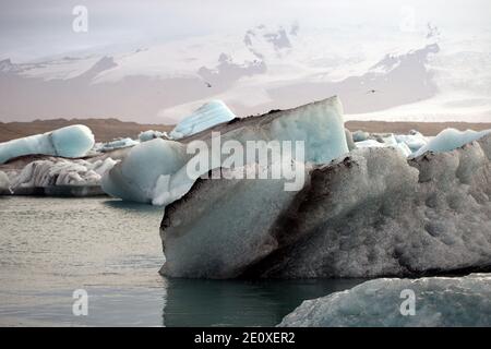 des flotteurs de glace sales flottent dans le lagon du glacier Banque D'Images