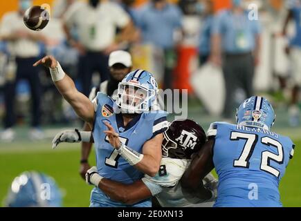 Miami, États-Unis. 02 janvier 2021. Caroline du Nord le quarterback de Tar Heels Sam Howell (7) est sous la pression de l'homme de ligne défensif de Texas A&M Aggies DeMarvin Leal (8) pendant la deuxième moitié du match de football de l'Orange Bowl au Hard Rock Stadium à Miami, le samedi 2 janvier 2021. Photo de Hans Deryk/UPI crédit: UPI/Alay Live News Banque D'Images