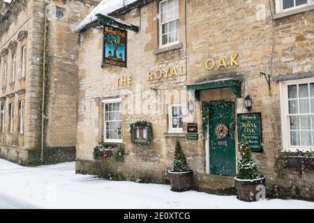 Le Royal Oak pub dans la neige à Witney Street à noël. Burford, Cotswolds, Oxfordshire, Angleterre Banque D'Images