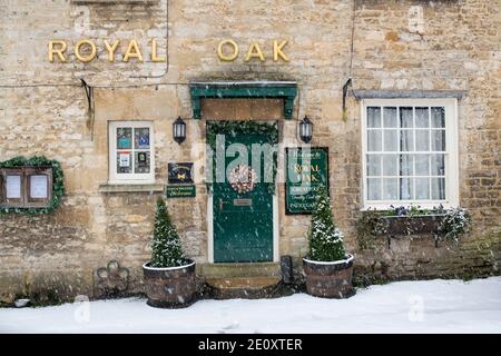 Le Royal Oak pub dans la neige à Witney Street à noël. Burford, Cotswolds, Oxfordshire, Angleterre Banque D'Images