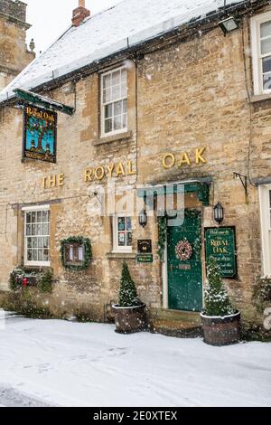 Le Royal Oak pub dans la neige à Witney Street à noël. Burford, Cotswolds, Oxfordshire, Angleterre Banque D'Images