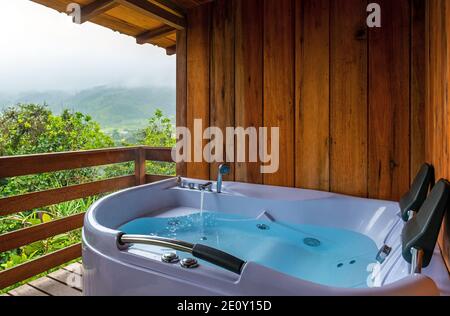 Jacuzzi sur un balcon avec vue sur la forêt nuageuse, Mindo, Equateur. Banque D'Images