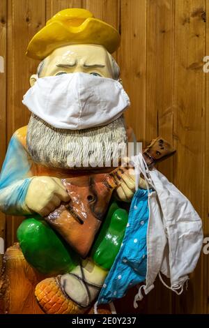 Une statuette dans un masque médical à la porte d'entrée de la maison. Banque D'Images