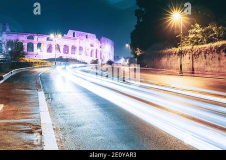 Rome, Italie. Vue sur le Colisée d'un autre côté la nuit. Feux de circulation de nuit près du célèbre site World Landmark Banque D'Images