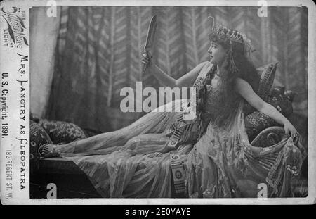 Lillie Langtry comme Cléopâtre, portrait en pied, couché sur le canapé et à la recherche dans le miroir Banque D'Images