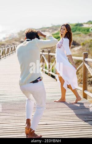 Homme photographiant sa petite amie lors d'un voyage d'amoureux. Banque D'Images