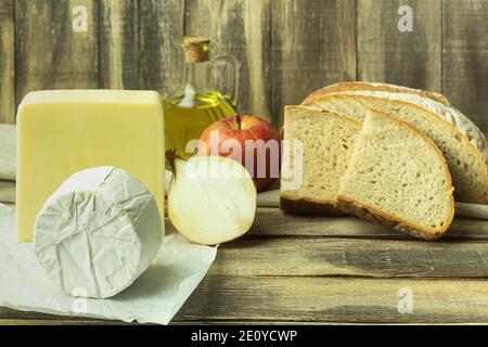 Fromage avec pain et oignons sur une table en bois. Cuisine médiévale. Tranche de pain au fromage frais Banque D'Images