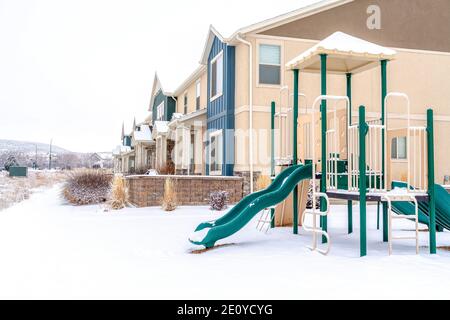 Aire de jeux pour enfants dans le quartier dans un cadre extérieur enneigé en hiver Banque D'Images