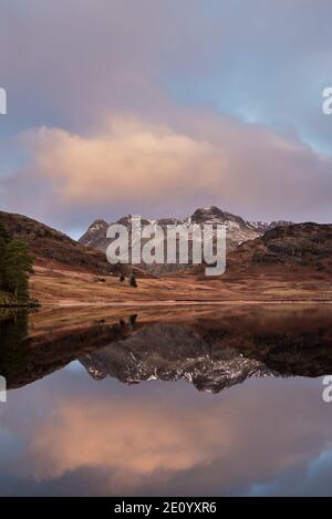 Magnifique lever de soleil d'hiver sur Blea Tarn dans Lake District avec Au loin, Langdale Pikes a été enneigé Banque D'Images