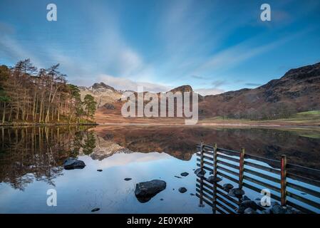 Magnifique lever de soleil d'hiver sur Blea Tarn dans Lake District avec Au loin, Langdale Pikes a été enneigé Banque D'Images