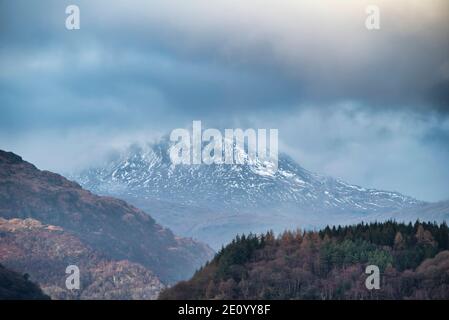 Belle image de paysage à travers le Loch Lomond en regardant vers la neige couverte Pic de Ben Lui dans les Highlands écossais Banque D'Images