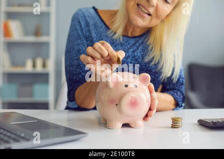Une femme âgée heureuse économisant de l'argent, gérant ses finances et planifiant son budget Banque D'Images