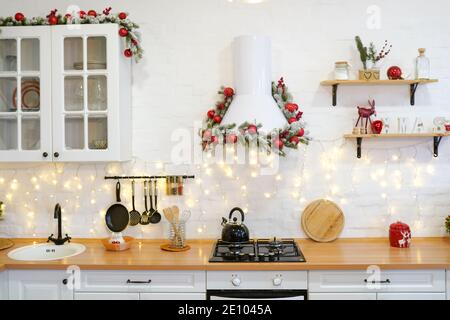 cuisine d'hiver avec décorations rouges, table de cuisson de noël et ustensiles Banque D'Images