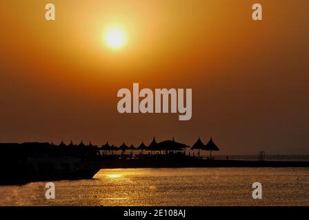 coucher de soleil à la mer et de nombreux parasols en egypte Banque D'Images