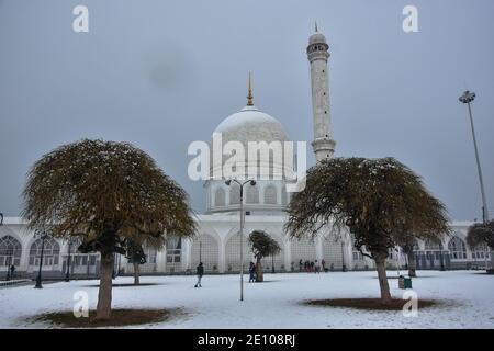 Srinagar, Inde. 03ème janvier 2021. Les visiteurs se promeussent dans un complexe couvert de neige du sanctuaire Hazratbal après une chute de neige fraîche à Srinagar.une chute de neige modérée à lourde a commencé dimanche à travers la vallée du Cachemire, coupant la surface de la vallée ainsi que la connexion aérienne avec le reste du monde, ont déclaré les responsables. L'homme météo a prévu une chute de neige étendue jusqu'au forenoon de décembre 6. Crédit : SOPA Images Limited/Alamy Live News Banque D'Images