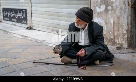 Yazd, Iran - Mai 2019 : ancien mendiant musulman assis dans une rue de la ville de Yazd Banque D'Images
