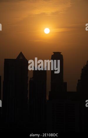 Horizon de Dubaï au coucher du soleil avec ciel orange et jaune sur les gratte-ciels des Émirats arabes Unis. (Vue portrait) Banque D'Images
