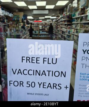 Un avis dans la fenêtre d'un chimiste, un drugstore offrant plus de cinquante personnes de vaccination gratuite contre la grippe. Banque D'Images