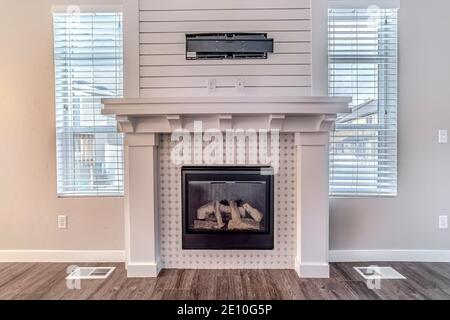 Foyer moderne et support de télévision contre le mur blanc et deux fenêtres Banque D'Images