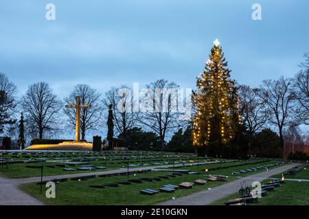 Sankariristi, une croix de bronze de Wäinö Aaltonen, et un arbre de Noël derrière des tombes militaires dans le cimetière de Hietaniemi, Helsinki, Finlande Banque D'Images