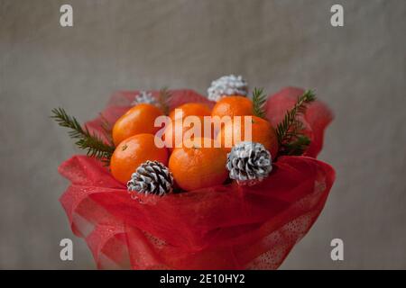 Bouquet de mandarines et branches d'arbres de Noël. Bouquet de fruits comestibles du nouvel an. Cadeau de Noël. Cadeau à faire soi-même. Cadeau utile fait de fruits. Décor Banque D'Images