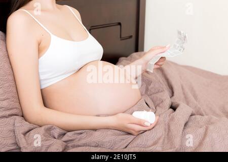 Femme enceinte lecture instructions pour les pilules prescrites, concept de soins de santé, médecine pendant la grossesse. Banque D'Images