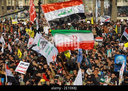 Bagdad, Irak. 03ème janvier 2021. Les Irakiens tiennent des drapeaux lors d'une manifestation sur la place Tahrir pour commémorer le premier anniversaire de l'assassinat du commandant militaire iranien et chef de ses forces Quds, le général Qasem Soleimani, tué par l'attaque aérienne américaine près de l'aéroport de Bagdad. Credit: Ameer Al Mohmedaw/dpa/Alamy Live News Banque D'Images