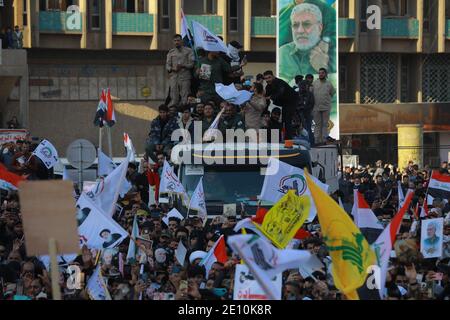 Bagdad, Irak. 03ème janvier 2021. Les Irakiens tiennent des drapeaux lors d'une manifestation sur la place Tahrir pour commémorer le premier anniversaire de l'assassinat du commandant militaire iranien et chef de ses forces Quds, le général Qasem Soleimani, tué par l'attaque aérienne américaine près de l'aéroport de Bagdad. Credit: Ameer Al Mohmedaw/dpa/Alamy Live News Banque D'Images