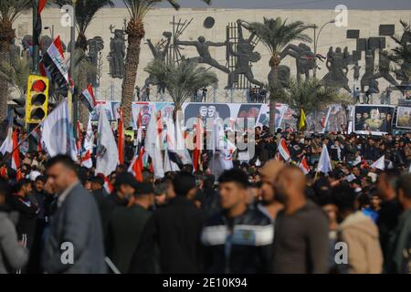 Bagdad, Irak. 03ème janvier 2021. Les Irakiens tiennent des drapeaux lors d'une manifestation sur la place Tahrir pour commémorer le premier anniversaire de l'assassinat du commandant militaire iranien et chef de ses forces Quds, le général Qasem Soleimani, tué par l'attaque aérienne américaine près de l'aéroport de Bagdad. Credit: Ameer Al Mohmedaw/dpa/Alamy Live News Banque D'Images