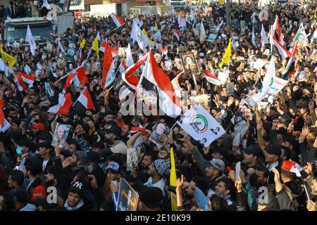 Bagdad, Irak. 03ème janvier 2021. Les Irakiens tiennent des drapeaux lors d'une manifestation sur la place Tahrir pour commémorer le premier anniversaire de l'assassinat du commandant militaire iranien et chef de ses forces Quds, le général Qasem Soleimani, qui a été tué par une frappe aérienne américaine près de l'aéroport de Bagdad. Credit: Ameer Al Mohmedaw/dpa/Alamy Live News Banque D'Images