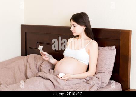 Femme enceinte lecture instructions pour les pilules prescrites, concept de soins de santé, médecine pendant la grossesse. Banque D'Images