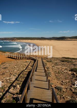 Sentier de randonnée en bois menant à la plage déserte de sable de surf Praia Da bordeira baie océanique atlantique à Carrapateira côte Algarve Portugal Banque D'Images