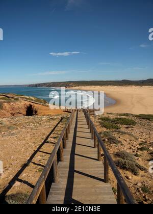 Sentier de randonnée en bois menant à la plage déserte de sable de surf Praia Da bordeira baie océanique atlantique à Carrapateira côte Algarve Portugal Banque D'Images