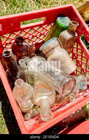 Caisse en plastique de vieux flacons en verre poussiéreux, vue verticale Banque D'Images