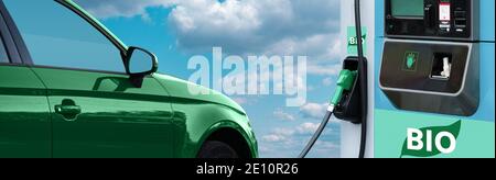 Station de remplissage de biocarburants avec voiture verte sur fond bleu ciel. Banque D'Images