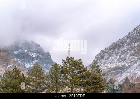 Église avec statue dorée au milieu d'une vue pittoresque sur la nature montagne enneigée Banque D'Images
