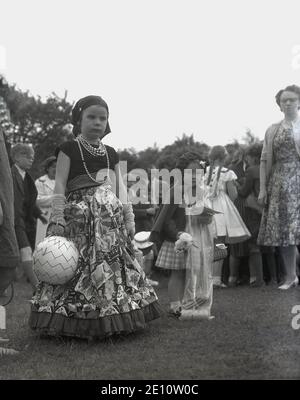 Années 1950, historique, deux petites filles vêtues de costumes pour un défilé à la Rose Queen Celebrations, Farnworth, Angleterre, Royaume-Uni. Banque D'Images