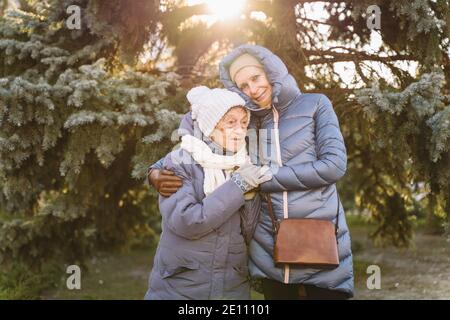 Maternité. Thème importance visiter et passer du temps avec les vieux parents célibataires pendant les vacances. Maman et fille mature hug et la famille heureuse Banque D'Images