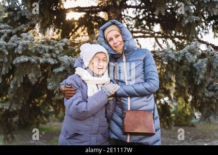 Maternité. Thème importance visiter et passer du temps avec les vieux parents célibataires pendant les vacances. Maman et fille mature hug et la famille heureuse Banque D'Images