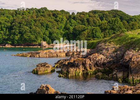 Marcher vers Elberry Cove, Torbay, Angleterre, Royaume-Uni - avec l'ancienne baignoire-maison sur le bord de la plage de galets Banque D'Images