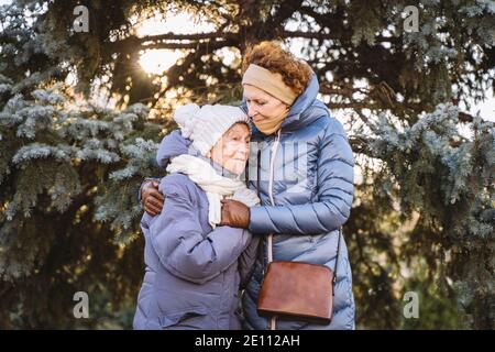 Maternité. Thème importance visiter et passer du temps avec les vieux parents célibataires pendant les vacances. Maman et fille mature hug et la famille heureuse Banque D'Images