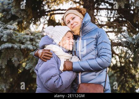 Maternité. Thème importance visiter et passer du temps avec les vieux parents célibataires pendant les vacances. Maman et fille mature hug et la famille heureuse Banque D'Images