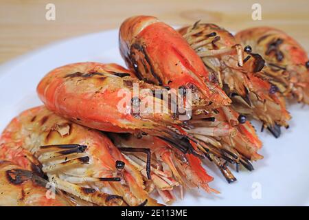 Gros plan sur de savoureuses crevettes de la rivière grillées sur un blanc Plaque Banque D'Images