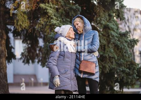 Maternité. Thème importance visiter et passer du temps avec les vieux parents célibataires pendant les vacances. Maman et fille mature hug et la famille heureuse Banque D'Images