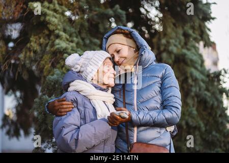 Maternité. Thème importance visiter et passer du temps avec les vieux parents célibataires pendant les vacances. Maman et fille mature hug et la famille heureuse Banque D'Images