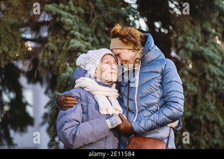 Maternité. Thème importance visiter et passer du temps avec les vieux parents célibataires pendant les vacances. Maman et fille mature hug et la famille heureuse Banque D'Images