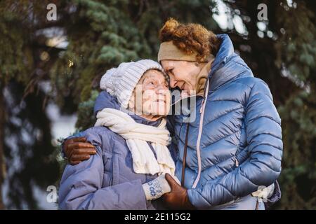 Maternité. Thème importance visiter et passer du temps avec les vieux parents célibataires pendant les vacances. Maman et fille mature hug et la famille heureuse Banque D'Images