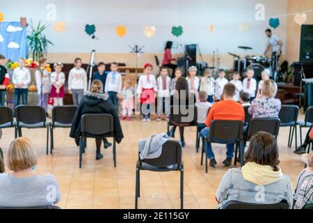 Parents à l'exécution d'enfants à la maternelle ou à l'école. Enfants sur scène. De nombreux parents regardent les enfants dans le hall pendant Banque D'Images