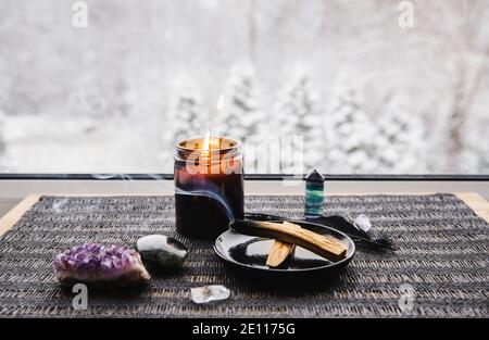 Bois de Palo Santo connu sous le nom de bâton de bois Saint aromatique huileux couvant sur plaque sur la maison seuil de fenêtre nettoyage négatif concept d'énergie. Bel hiver. Banque D'Images