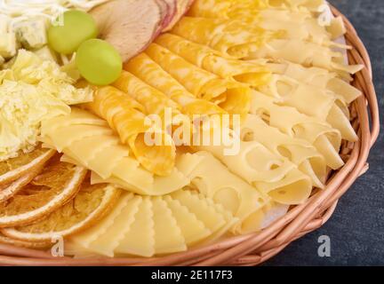 Différents types de fromage avec des tranches d'orange séchées, des tranches de pomme séchées et des raisins en gros plan Banque D'Images